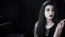 Goth girl with black eyes occasionally prefers dragging a 120mm cigarette