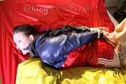 Watching sexy Jill being tied and gagged with ropes and a ballgag on a bed wearing a sexy red shiny nylon shorts and an oldschool rain jacket (Pics)