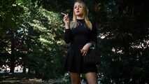 Blond lady is smoking white cigarette outdoors