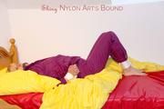 Pia in a shiny purple rainsuit tied and gagged in bed (Pics)