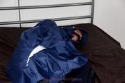 Simone tied and gagged in a shiny nylon rainsuit and a shiny nylon cape