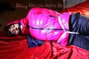 Mara tied, gagged and hooded on bed wearing a black rain pants and a pink down jacket (Pics)