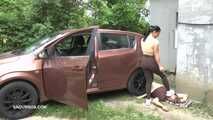 Mistress Jenna stands on the slave with a car while smoking in the slave's mouth A