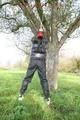 Jill tied and gagged outdoor on a tree wearing a sexy black downjacket and a black rain pants (Pics)