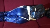 Lucy tied and gagged on a red sofa wearing a supersexy blue shiny nylon pants and a blue rain jacket (Video)