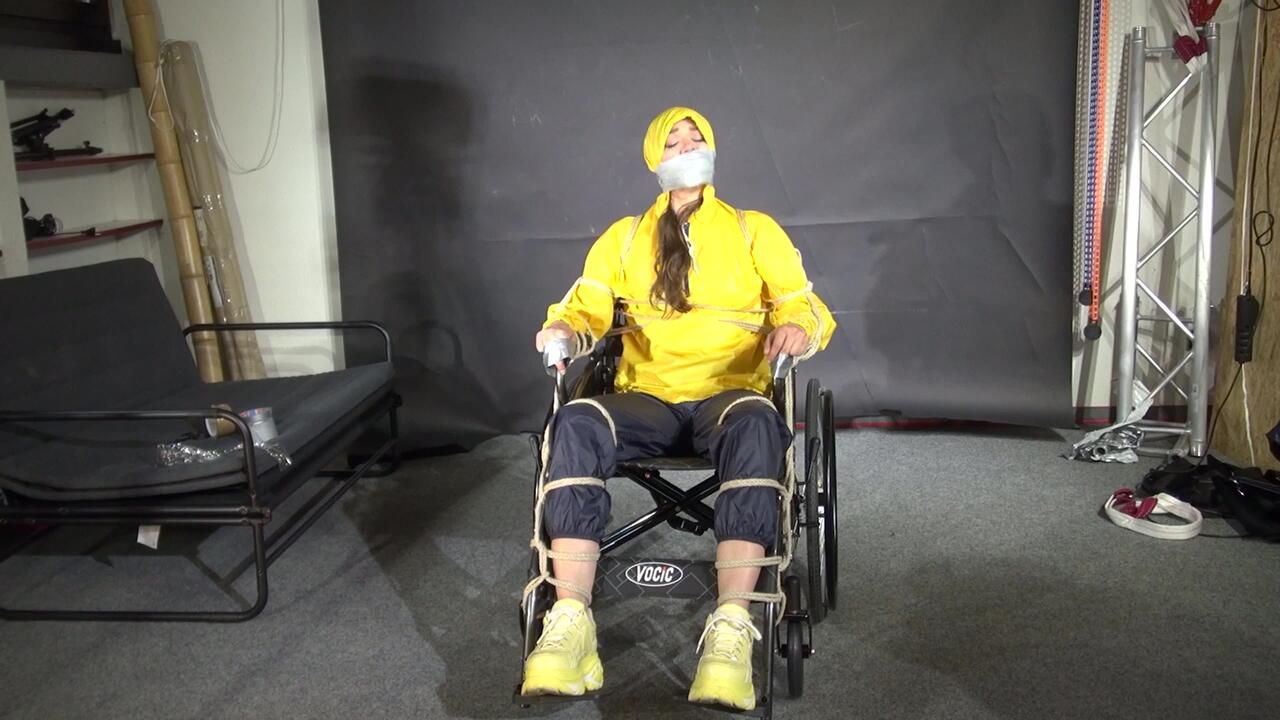 Watch Marie Bound To A Wheelchair And Tightly Gagged In Shiny Nylon Rainwear