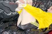 LUCY tied and gagged with ropes and a ballgag on a sofa wearing a sexy black/yellow shiny nylon shorts and a yellow rain jacket (Pics)