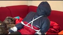 Jill tied, gagged and double hooded on a chair wearing shiny nylon shorts and two shiny nylon rain jackets (Video)