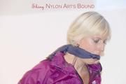 Pia in a shiny purple rainsuit tied and gagged in bed (Pics)