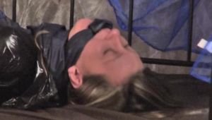 Alina tied and gagged in a princess bed standing in an old cellar wearing hot shiny nylon shorts and rainjacket (Video)