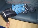 Katharina tied, gagged and hooded (breath control) on a sofa wearing sexy blue shiny nylon rainwear (Pics)