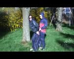 Jill and a friend of her playing with eachother in the garden while wearing shiny nylon rainwear (Video)