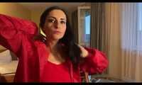 Miss Amira in a red minidress and red nylon raincoat having fun in a hotel room