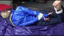 Samantha tied and gagged on bed wearing a shiny darkblue nylon rain pants and a light blue rain jacket (Video)