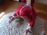 Black haired archive girl tied, gagged and hooded on the floor wearing a shiny red nylon shorts and a shiny red rain jacket (Video)