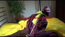 Lucy tied, gagged and hooded on bed on a bar wearing sexy purple rainwear (Video)