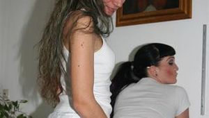 Jill and Petra touching eachother in front of a sofa wearing sexy shiny nylon shorts (Pics)