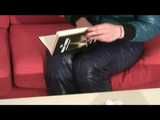 Alina wearing a sexy shiny crazy sensation skibib in blue and a green special down jacket reading on a sofa and playing with cuffs (Video)