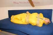 Archive girl tied and gagged by using tape on a sofa wearing an yellow rainsuit (Pics)