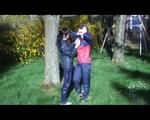 Jill and a friend of her playing with eachother in the garden while wearing shiny nylon rainwear (Video)
