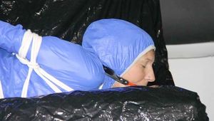 ***SEXY SANDRA*** wearing a supersexy skinny shiny nylon pants and a lightblue shiny nylon rain jacket being bound on a sofa with ropes and a ball gag (Pics)