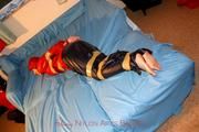 one of our archive girls tied and gagged in shiny nylon rainwear