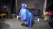 Watching sexy Sandra wearing a sexy blue shiny nylon rainpants and a blue down jacket being tied and gagged and hooded with ropes on a hairdressers chair covered with a rain cape (Video)