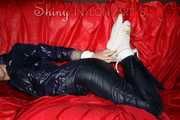 Sexy Courtney being tied and gagged with ropes and a ballgag on a bed wearing dark blue rainwear (Pics)