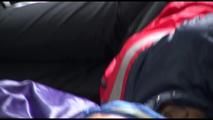 Samantha tied and gagged on bed wearing a shiny black adidas pants and a red/blue rain jacket (Video)