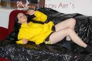 Lucy wearing a sexy black/yellow shiny nylon shorts and a yellow rain jacket preparing her sofa with a special cloth to enjoy it (Pics)