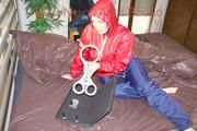 Jill tied, gagged and hooded with a pillory and cuffs wearing sexy shiny nylon rainwear (Pics)