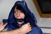 Simone tied and gagged in a shiny nylon rainsuit and a shiny nylon cape