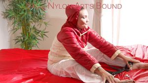Jill ties, gagges and hoodes herself with a bar on bed wearing a white shiny nylon rain pants and a white/red oldschool down jacket (Pics)