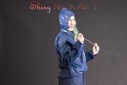 Mara posing in the studio wearing a blue rain skirt and a blue rain jacket as wellas red rubber boots (Pics)