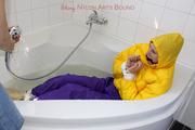 Julia tied and gagged in a ski suit in the bath tub
