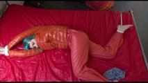 Mara tied and gagged on bed wearing a sexy orange shiny down jacket and a orange rain pants (Video)