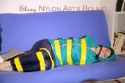 Mara tied and gagged with tape on a sofa wearing a supersexy shiny blue rain pants and a grren rain jacket (Pics) 