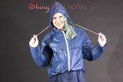 Mara posing in the studio wearing a blue rain skirt and a blue rain jacket as wellas red rubber boots (Pics)