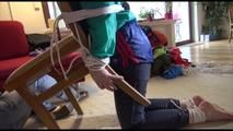 Mara tied, gagged and hooded on the back of an chair wearing a hot rain pants and a shiny nylon shorts over it and a rain jacket (Video)