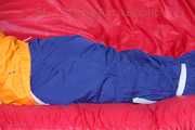 Lucy tied and gagged on a sofa wearing an orange shiny nylon rain jacket and a blue rain pants (Pics)