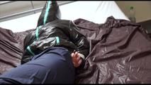 Jill tied, gagged and hooded on bed wearing a shiny black downjacket and shiny blue rain pants (Video)