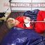 Pia tied and gagged on bed wearing a shiny red rain pants and a shiny red/purple down jacket (Pics)
