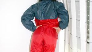 Stella wearing a red shiny nylon rain pants and an oldschool blue/red rain jacket while posing in the living room (Pics)