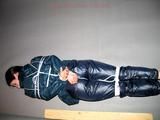 One of our archive girls tied and gagged in shiny nylon rainwear