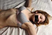 Barefoot tapegagged Grace in grey lace polka dot bra and panties, tied on the bed with her hands and legs wide-spread, wiggles helplessly