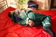 Lucy tied and gagged on bed wearing a sexy green rainwear combination (Pics)