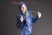 Mara posing in the studio wearing a blue rain skirt and a blue rain jacket as wellas red rubber boots (Pics)