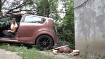 Mistress Jenna stands on the slave with a car while smoking in the slave's mouth A