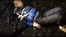 Pia tied, gagged and hooded lying on a bed with shiny nylon cloth wearing a sexy black adidas nylon pants and a blue down jacket(Video)