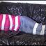 Mara tied and gagged with tape on a blue sofa wearing a supersexy pink/grey rainwear combination (Video)